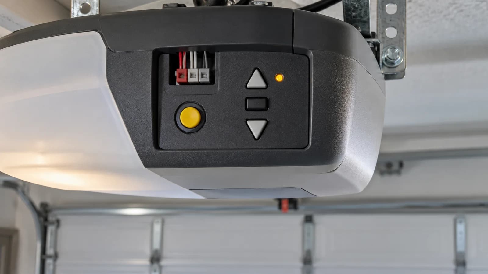 Garage door opener control panel with up and down diagnostic arrows and a yellow learn button